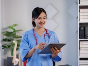 A picture showing a female healthcare worker on an electronic device.