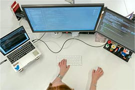 laptop and two computer screens