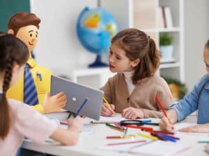 A picture of a young girl in a classroom with a System C Education character with an electronic device.