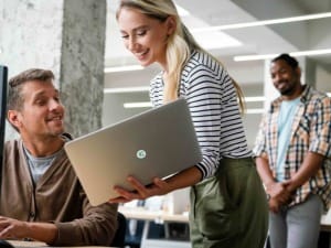 a picture of 3 social care workers on a System C laptop.