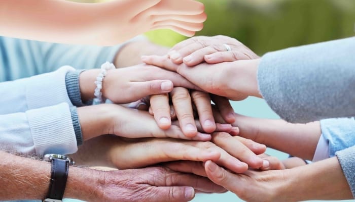 Multiple hands stacked on top of each other, symbolising teamwork.