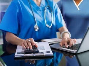 A picture of a healthcare professional using a calculator tool on a desktop.